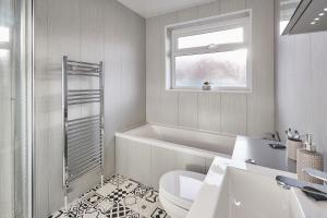 ein Badezimmer mit einer Badewanne, einem WC und einem Waschbecken in der Unterkunft Host & Stay - Station Cottage in Saltburn-by-the-Sea