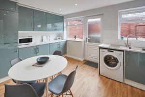 a kitchen with a white table and chairs at Host & Stay - Station Cottage in Saltburn-by-the-Sea +13 photos