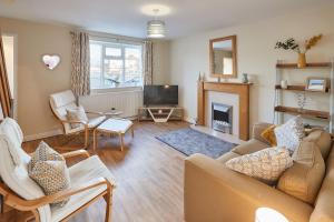 ein Wohnzimmer mit einem Sofa und einem TV in der Unterkunft Host & Stay - Station Cottage in Saltburn-by-the-Sea