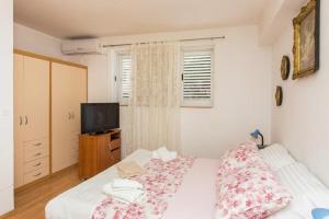 1 dormitorio con 1 cama y TV. en Apartment Stella Polaris, en Dubrovnik