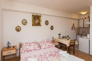 ein Schlafzimmer mit einem Bett und einem Tisch sowie eine Küche in der Unterkunft Apartment Stella Polaris in Dubrovnik