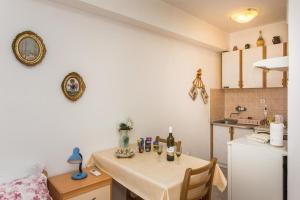 cocina con mesa y cocina pequeña con nevera en Apartment Stella Polaris, en Dubrovnik