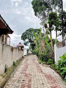 a cobblestone street in a village with trees at we are one apartment in Arusha
