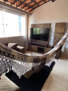 a hammock in a living room with a television at Ilha do amor in Camocim