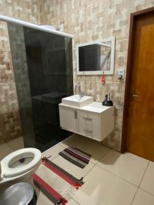 bagno con servizi igienici, lavandino e specchio di Ilha do amor a Camocim