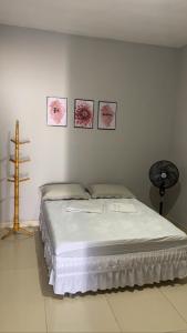 łóżko w pokoju z trzema zdjęciami na ścianie w obiekcie Ilha do amor w mieście Camocim