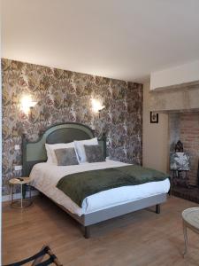 a bedroom with a large bed and a fireplace at Chambres d'hôtes Domaine des Formes in Effiat