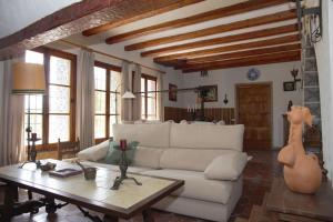 sala de estar con sofá blanco y mesa en Mas de Paco, Chimenea, barbacoa y piscina en Vall dʼAlba