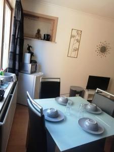 una cocina con una mesa con platos. en Chambre 2/4p confortable, en Ostende