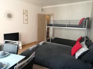 Schlafzimmer mit einem Bett, einem Schreibtisch und einem Etagenbett in der Unterkunft Chambre 2/4p confortable in Ostende