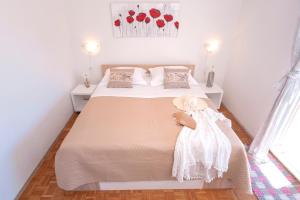 lalka siedząca na łóżku w sypialni w obiekcie Apartment Katarina Vrboska w mieście Vrboska
