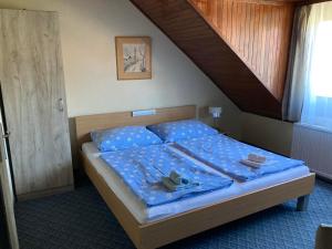 a bedroom with a bed with blue sheets and a staircase at FARKAS VENDÉGHÁZ in Sopron
