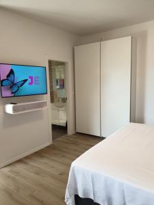 - une chambre avec un lit et une télévision murale dans l'établissement Apartments Vinka, à Jelsa