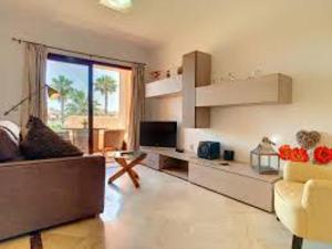 a living room with a couch and a television at 2 Bed Sleeps 4 Pet Friendly Free Parking in Los Alcázares