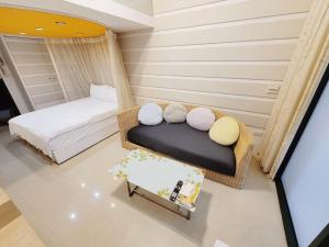 a room with a bed and a couch with pillows at 暖暖窩溫泉湯旅 in Yü-shih-ts'un