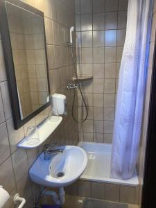 baño con lavabo y cortina de ducha en FARKAS VENDÉGHÁZ, en Sopron