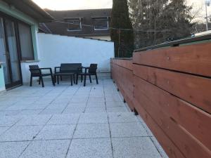 un patio con 2 mesas y sillas y una valla en FARKAS VENDÉGHÁZ en Sopron