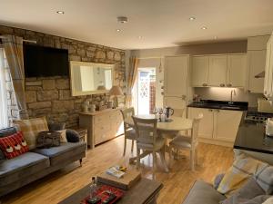 a kitchen and living room with a table and a couch at Linden Studio in Morpeth