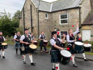 um grupo de pessoas em kilts tocando bateria em Linden Studio em Morpeth