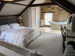 a bedroom with a large bed and a bath tub at Linden Studio in Morpeth