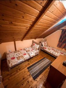 Cette chambre mansardée comprend 2 lits et un plafond en bois. dans l'établissement Chalet Breza, à Kolašin