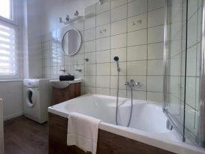 La salle de bains est pourvue d'une baignoire, d'une douche et d'un lavabo. dans l'établissement Happy Seagull by 3City Rentals, à Sopot