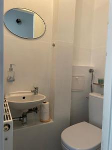 La salle de bains est pourvue d'un lavabo, de toilettes et d'un miroir. dans l'établissement Happy Seagull by 3City Rentals, à Sopot