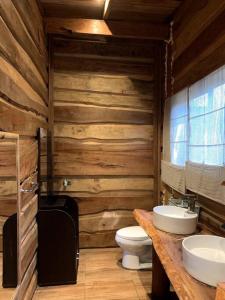La salle de bains en bois est pourvue de toilettes et d'un lavabo. dans l'établissement route 199 cabaña exclusiva centro de eventos, à Pucón