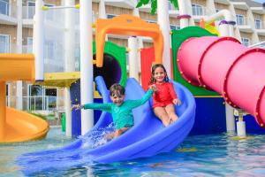 two children are riding on a slide on a water park at Maragogi Brisa Exclusive Hotel in Maragogi