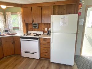 een witte koelkast in een keuken met houten kasten bij Waterway Inn in Indian River