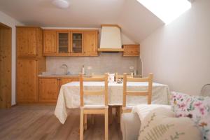 - une cuisine avec une table et des chaises dans la chambre dans l'établissement Apartments pr' Špeli, à Bohinj