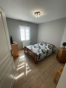 a bedroom with a bed and a wooden floor at Maison au sein d’un corps de ferme. 