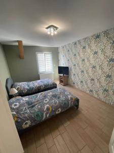 a bedroom with two beds and a television in it at Maison au sein d’un corps de ferme. in Carpiquet