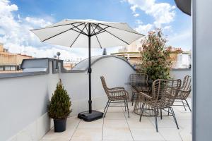 a patio with a table and chairs and an umbrella at Ayala 63 - THE ARC COLLECTION in Madrid