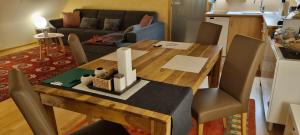 a wooden dining room table with chairs and a kitchen at Apartment Mittelpunkt - Kaufmann in Sankt Stefan ob Leoben