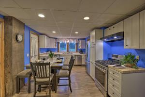 cocina con paredes azules, mesa y sillas en Pet-Friendly Seneca Lake Home with Private Deck, en Ovid