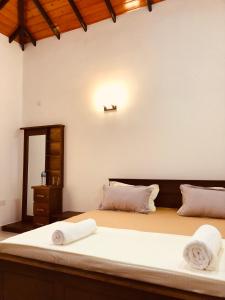 a bedroom with a large bed with towels on it at Sanrish Airport Villa in Negombo