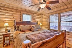 a log cabin bedroom with a large bed and a ceiling fan at 'Sleeping Bear Cabin' Coosawattee! Dog Friendly! in Ellijay