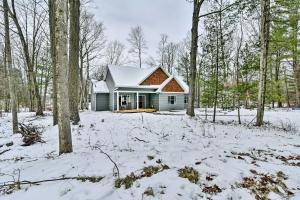 een huis in het bos in de sneeuw bij Pet-Friendly Wixom Lake Home with Deck! in Beaverton