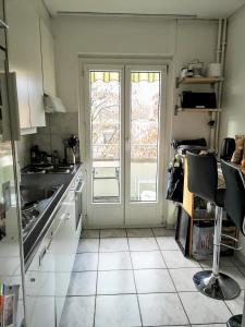una cocina con puerta y ventana. en Cozy Private Room in The Heart Of Zürich City, en Zúrich