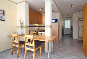 een keuken en eetkamer met een houten tafel en stoelen bij Meeresblick Wohnung 404 in Kühlungsborn