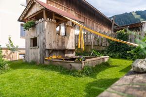 a wooden bird house in the grass next to a house at Hartlhof Urlaub am Baby- und Kinderbauernhof in Niederau
