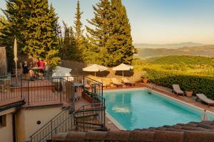 uma piscina com cadeiras e guarda-sóis em Si Montalcino Hotel em Montalcino