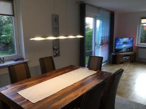 a dining room with a wooden table and chairs at Ferienwohnung Kajüte in Wees