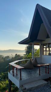 a house with a blue roof and a porch at ภูคำฮ้อมคลิฟฟ์ลอดจ์ แอนด์ โฮมสเตย์ Phu come home cliff Lodge & Homestay in Ban Phu Hi