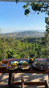 een tafel met borden met voedsel erop met uitzicht bij ภูคำฮ้อมคลิฟฟ์ลอดจ์ แอนด์ โฮมสเตย์ Phu come home cliff Lodge & Homestay in Ban Phu Hi