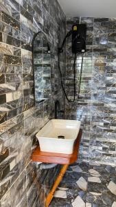 een badkamer met een wastafel en een spiegel bij ภูคำฮ้อมคลิฟฟ์ลอดจ์ แอนด์ โฮมสเตย์ Phu come home cliff Lodge & Homestay in Ban Phu Hi