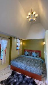 a bedroom with a bed and a chandelier at ภูคำฮ้อมคลิฟฟ์ลอดจ์ แอนด์ โฮมสเตย์ Phu come home cliff Lodge & Homestay in Ban Phu Hi +29 photos
