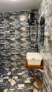 La salle de bains est pourvue d'un lavabo et d'un mur en carrelage. dans l'établissement ภูคำฮ้อมคลิฟฟ์ลอดจ์ แอนด์ โฮมสเตย์ Phu come home cliff Lodge & Homestay, à Ban Phu Hi
