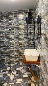 a bathroom with a sink and a tile wall at ภูคำฮ้อมคลิฟฟ์ลอดจ์ แอนด์ โฮมสเตย์ Phu come home cliff Lodge & Homestay in Ban Phu Hi
